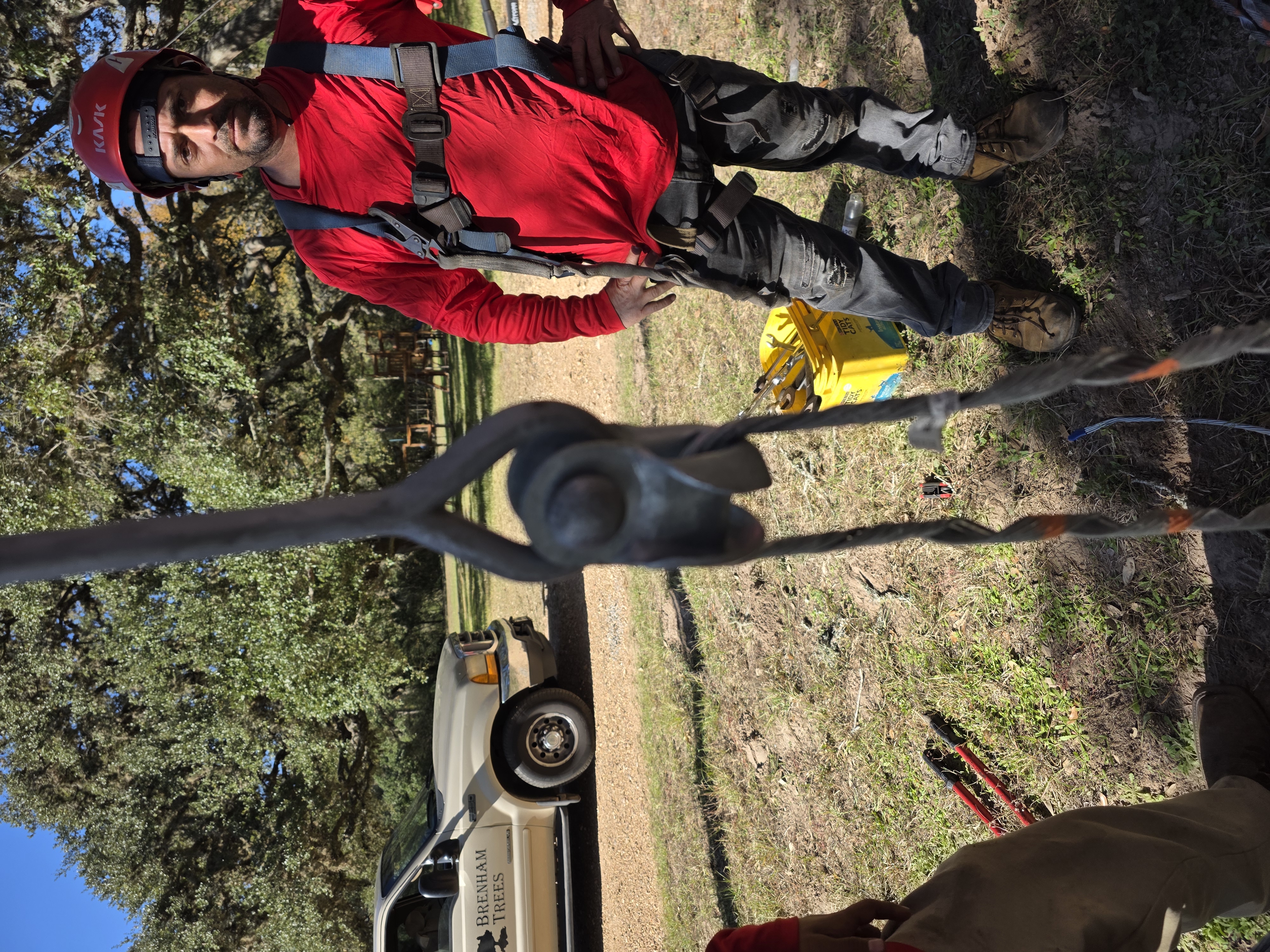 Climber in full saddle and helmet rigging up before going aloft
