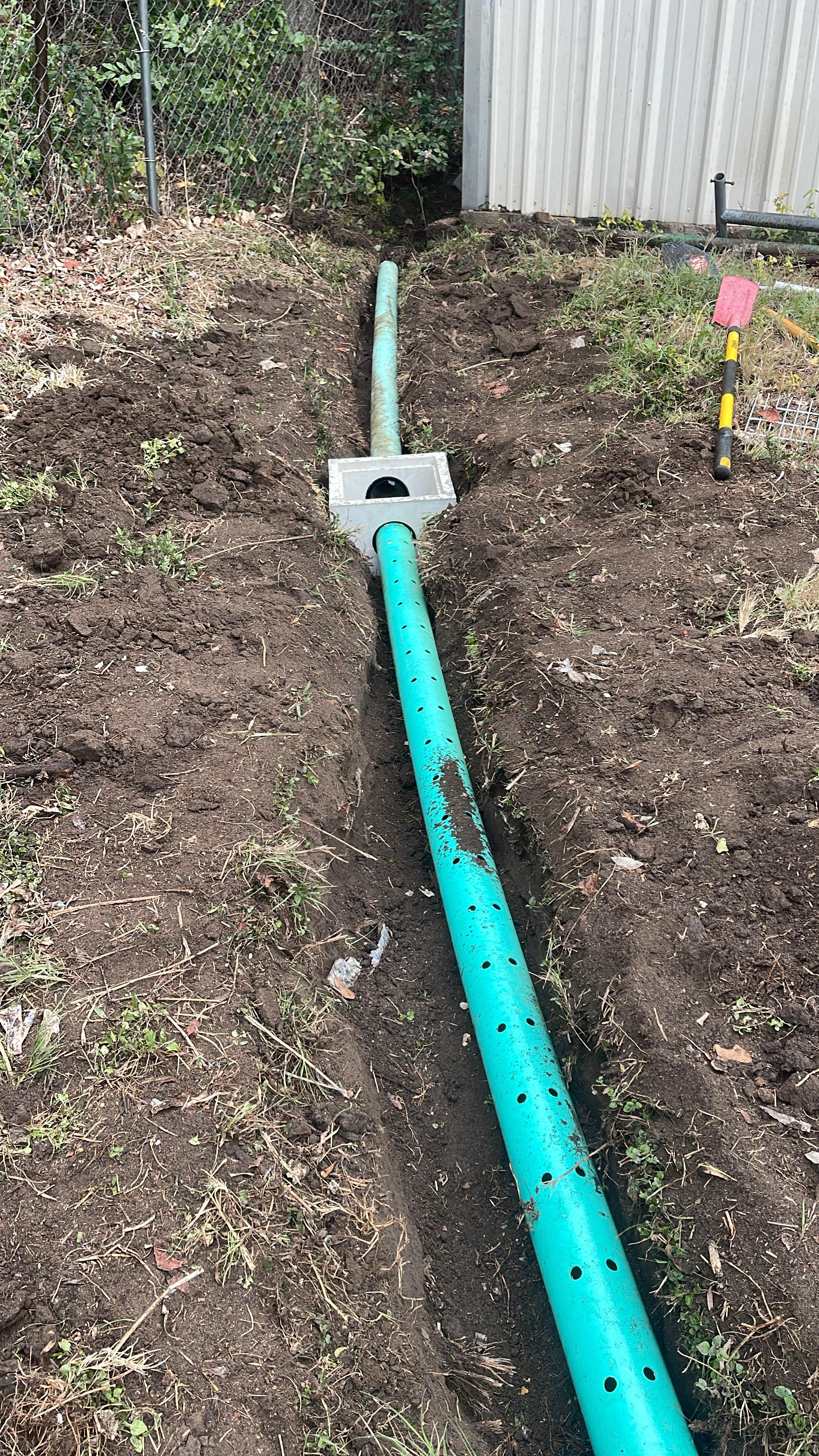 New drainage line installed beside a freshly worked tree area
